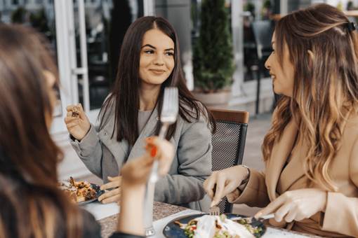 Group of women having meals in restaurant