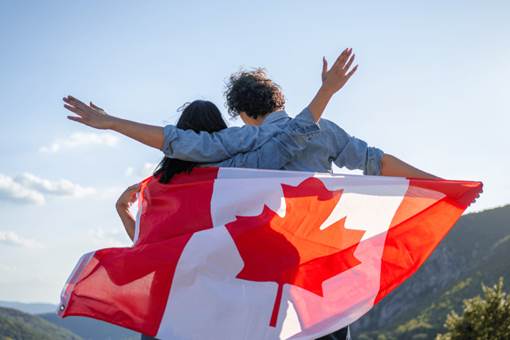 Couples on the mountain with a Canadian flag